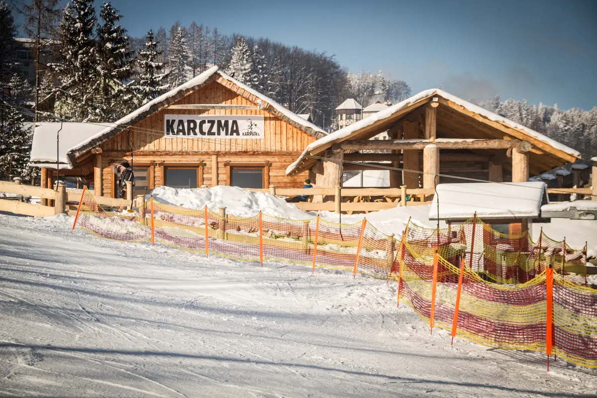 Karczma Karpatka zimą, tuż przy ogrodzonym stoku narciarskim w Karpaczu